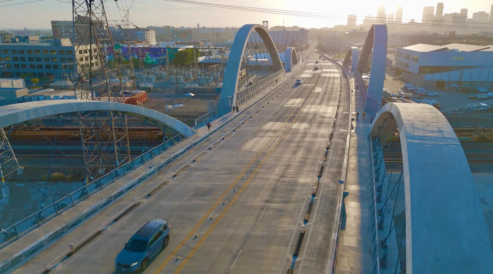 A bridge leads into the Los Angeles skyline